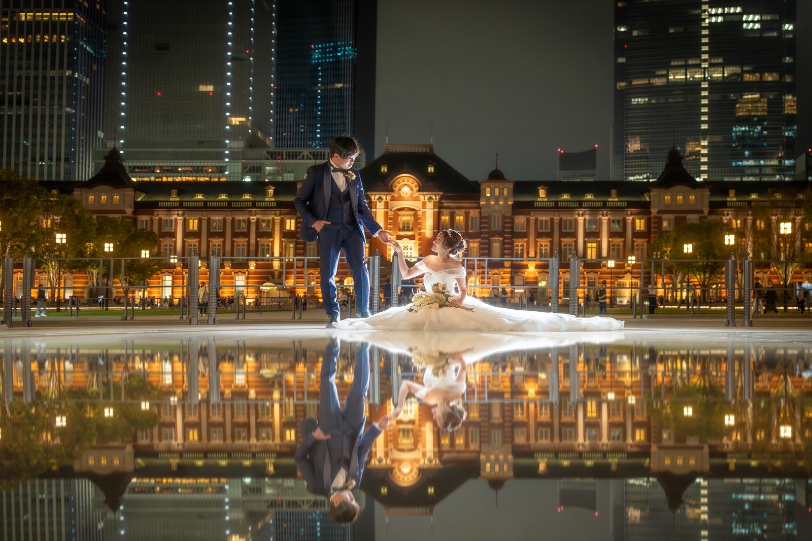 夜の東京駅丸の内駅舎を背に、水面に映る新郎新婦